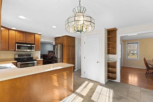 kitchen featuring light countertops, recessed lighting, a peninsula, brown cabinets, and stainless steel appliances