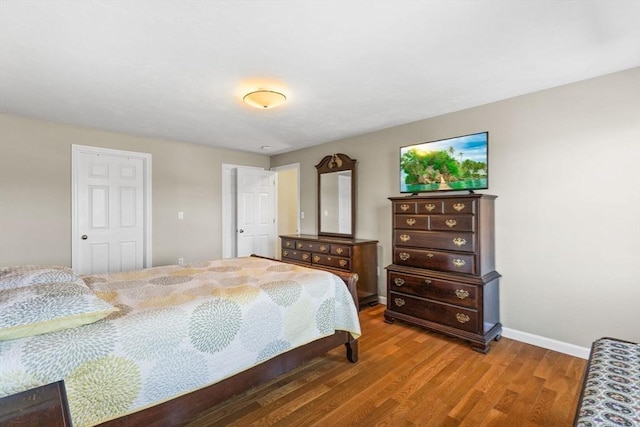 bedroom with baseboards and wood finished floors