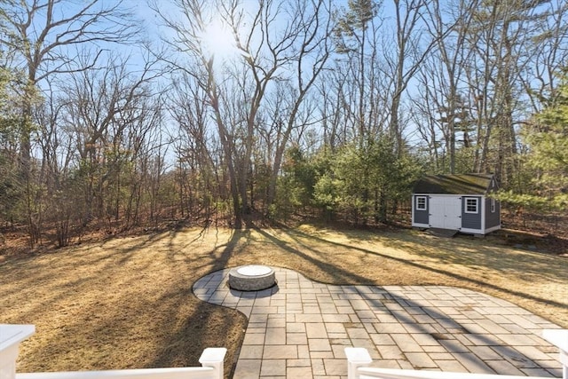 view of yard featuring a patio area, a storage unit, and an outbuilding