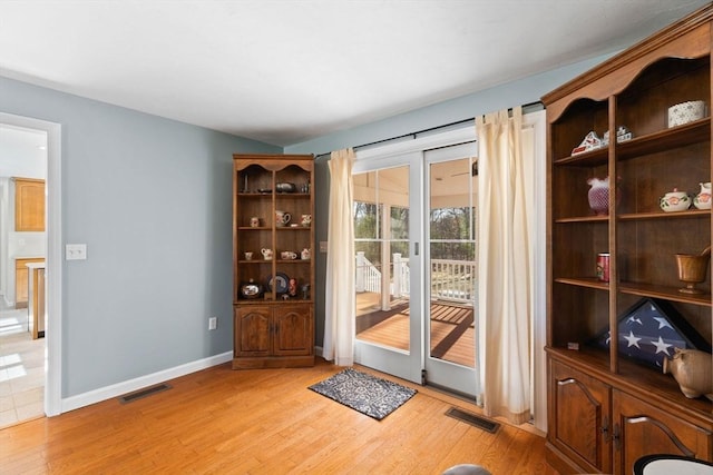 doorway to outside with visible vents, light wood-style flooring, and baseboards