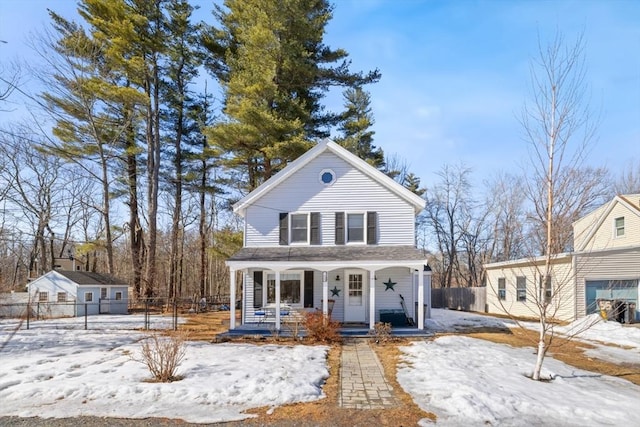 traditional-style house featuring covered porch and fence