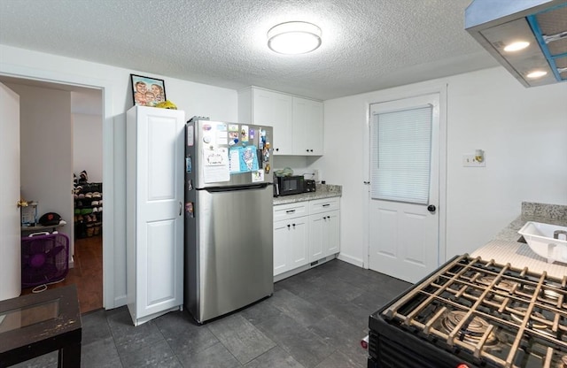 258-260 Pleasant St, Lowell, MA 01852 - kitchen with freestanding refrigerator, range with gas cooktop, black microwave, white cabinets, and a textured ceiling