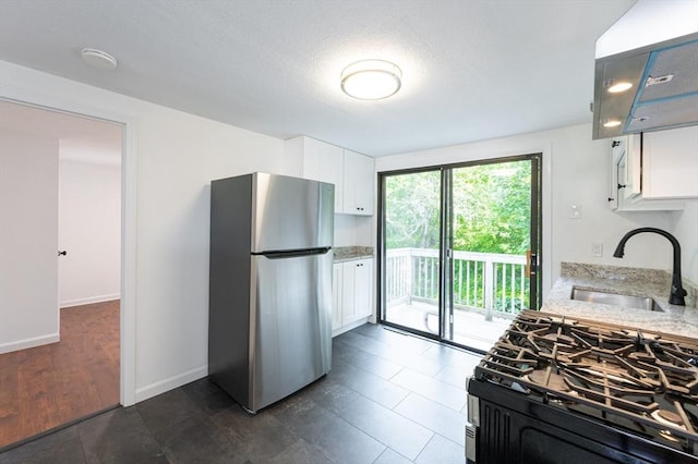 258-260 Pleasant St, Lowell, MA 01852 - kitchen with freestanding refrigerator, a sink, range with gas stovetop, and white cabinetry