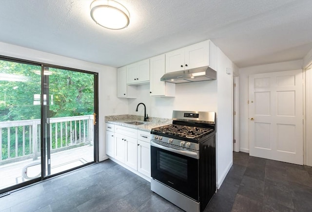 258-260 Pleasant St, Lowell, MA 01852 - kitchen featuring stainless steel range with gas cooktop, under cabinet range hood, a sink, light stone counters, and white cabinetry