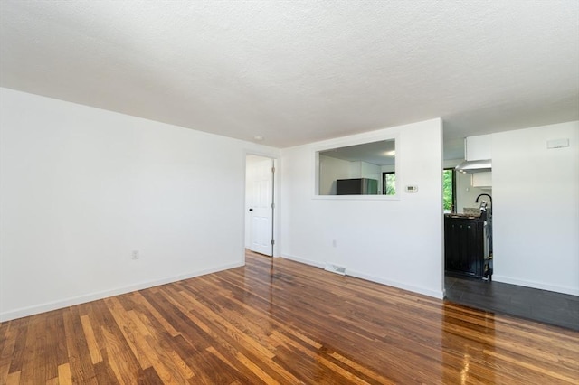258-260 Pleasant St, Lowell, MA 01852 - spare room with dark wood-type flooring, baseboards, and a textured ceiling