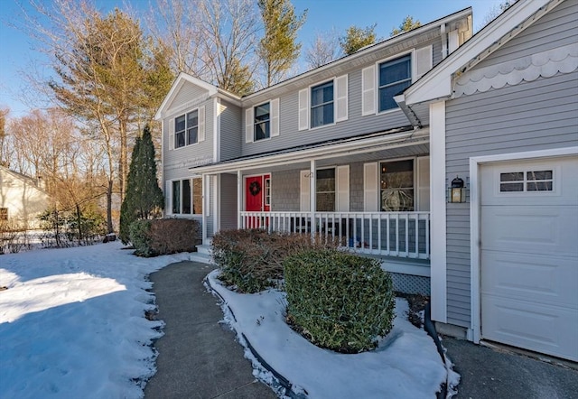 view of property with a porch and a garage