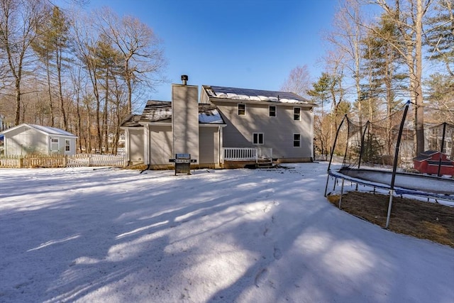 snow covered house featuring a trampoline