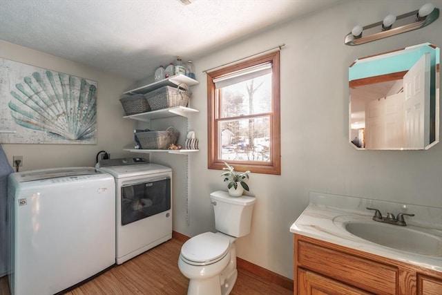 bathroom with vanity, hardwood / wood-style flooring, washer and dryer, and toilet