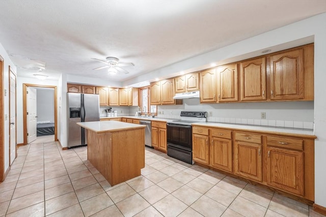 kitchen with sink, ceiling fan, appliances with stainless steel finishes, a center island, and light tile patterned flooring