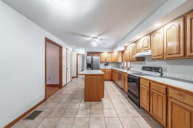 kitchen featuring sink, ceiling fan, appliances with stainless steel finishes, a center island, and light tile patterned flooring