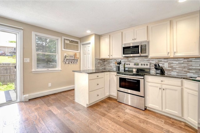 1608 Plymouth St Unit 1608, East Bridgewater, MA 02333 - kitchen featuring appliances with stainless steel finishes, a baseboard heating unit, an AC wall unit, a peninsula, and backsplash