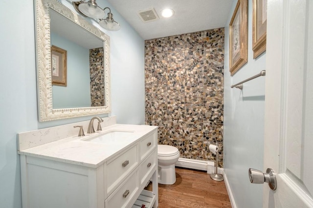 1608 Plymouth St Unit 1608, East Bridgewater, MA 02333 - bathroom featuring toilet, vanity, wood finished floors, baseboard heating, and baseboards
