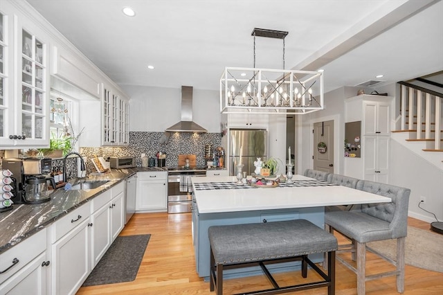 6 Edgehill Rd, Billerica, MA 01862 - kitchen with appliances with stainless steel finishes, wall chimney exhaust hood, white cabinets, a kitchen island, and glass insert cabinets