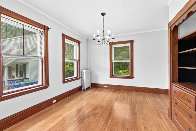 181 Myrtle St, Rockland, MA 02370 - empty room with radiator heating unit, a chandelier, baseboards, crown molding, and plenty of natural light