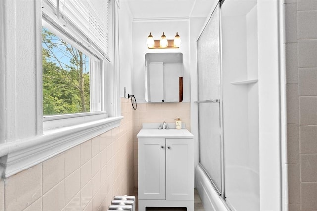 181 Myrtle St, Rockland, MA 02370 - bathroom featuring a shower with door, tile walls, vanity, and radiator heating unit