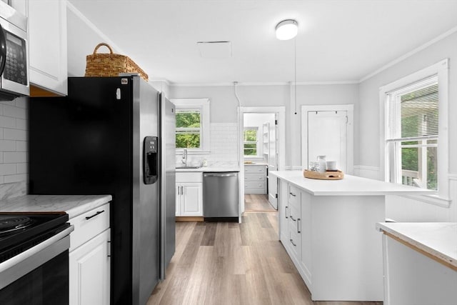 181 Myrtle St, Rockland, MA 02370 - kitchen featuring appliances with stainless steel finishes, light wood finished floors, a sink, white cabinets, and light countertops
