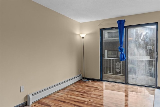 262 E Haverhill St Unit 17, Lawrence, MA 01841 - empty room with a baseboard radiator, wood finished floors, and baseboards