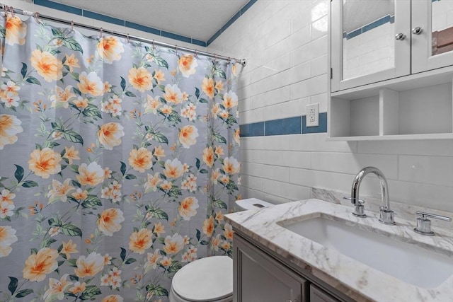 262 E Haverhill St Unit 17, Lawrence, MA 01841 - full bathroom with tile walls, toilet, vanity, decorative backsplash, and a shower with shower curtain