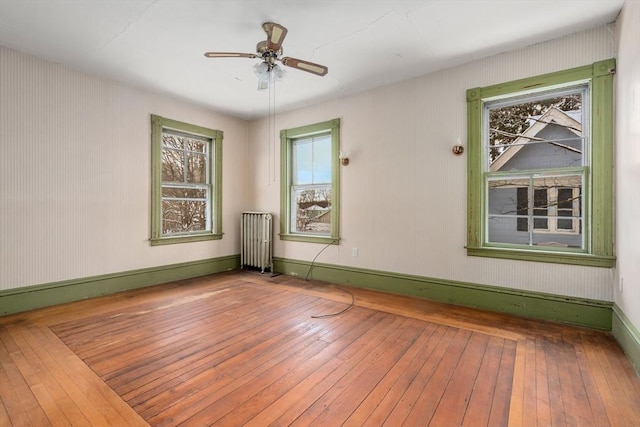 spare room with radiator, ceiling fan, and hardwood / wood-style floors