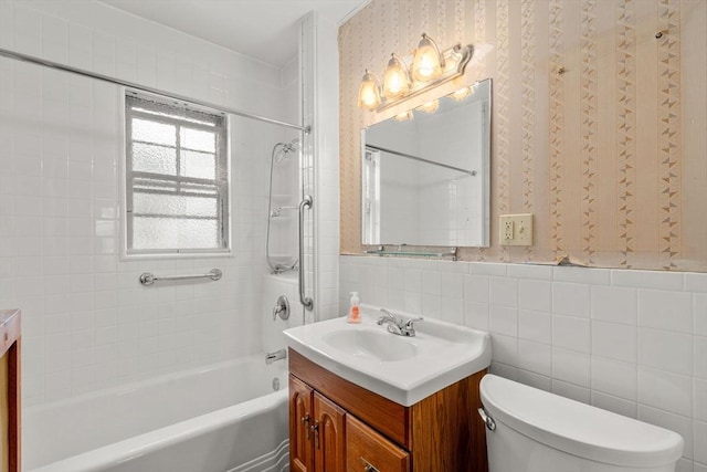 full bathroom featuring tile walls, toilet, vanity, and tiled shower / bath