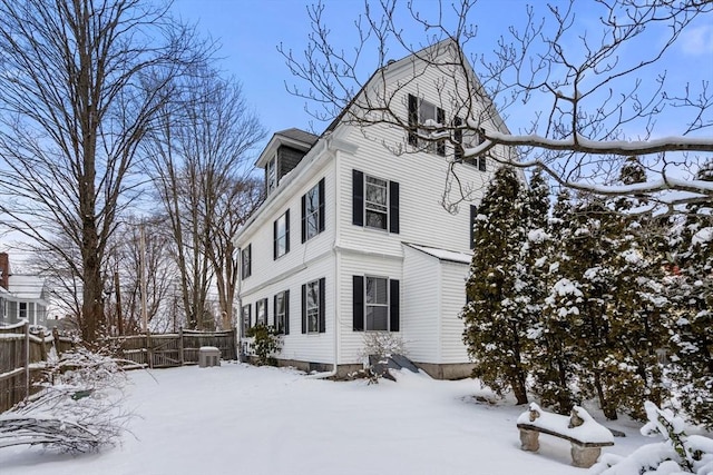 snow covered property with central AC