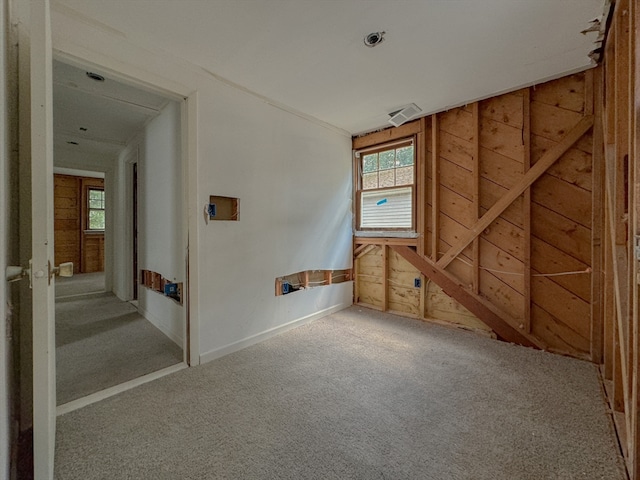 unfurnished room with wooden walls and carpet