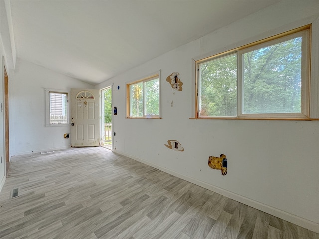 empty room featuring vaulted ceiling and hardwood / wood-style floors