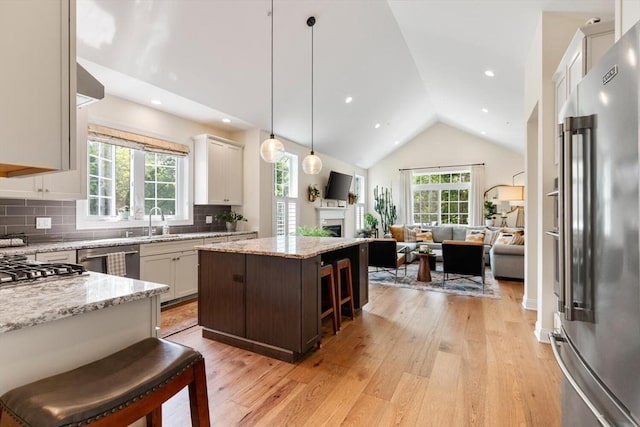 109 Phoebe St Unit 109, Methuen, MA 01844 - kitchen with appliances with stainless steel finishes, open floor plan, vaulted ceiling, light wood-style floors, and a kitchen island