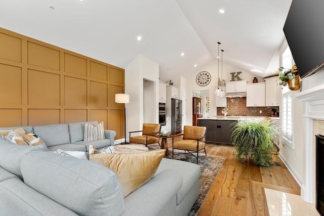 109 Phoebe St Unit 109, Methuen, MA 01844 - living room with light wood finished floors, high vaulted ceiling, a premium fireplace, and a decorative wall