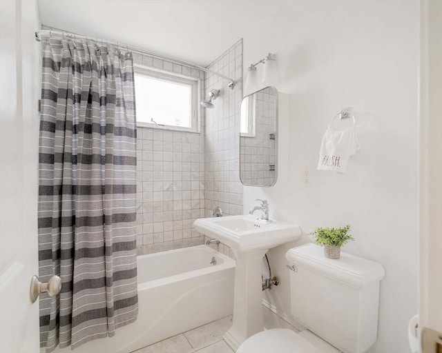 bathroom featuring toilet, shower / bath combo with shower curtain, and tile patterned floors