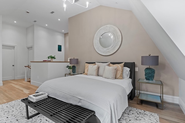 bedroom featuring lofted ceiling and light hardwood / wood-style flooring