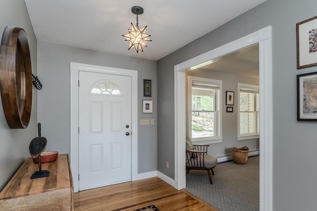 foyer entrance with baseboards, wood finished floors, and baseboard heating