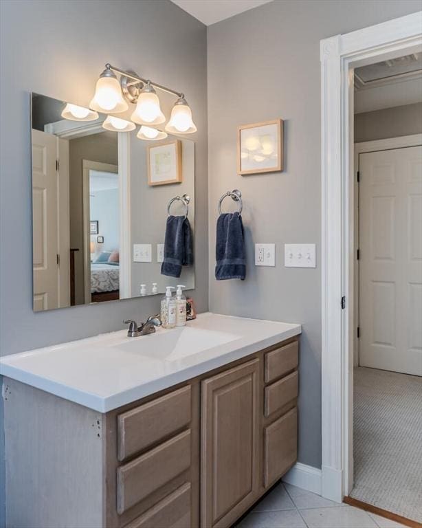 bathroom with vanity, ensuite bathroom, baseboards, and tile patterned flooring