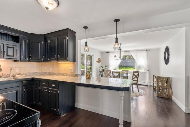 5 Eclipse Ave, Chelmsford, MA 01824 - kitchen with dark cabinets, backsplash, dark wood-type flooring, and a peninsula