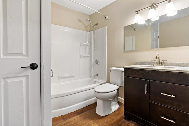 full bathroom with washtub / shower combination, hardwood / wood-style floors, vanity, and toilet