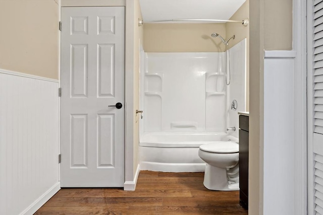 bathroom featuring bathtub / shower combination, wood-type flooring, and toilet