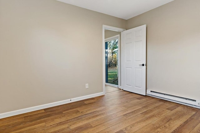 spare room featuring light wood-type flooring and a baseboard radiator