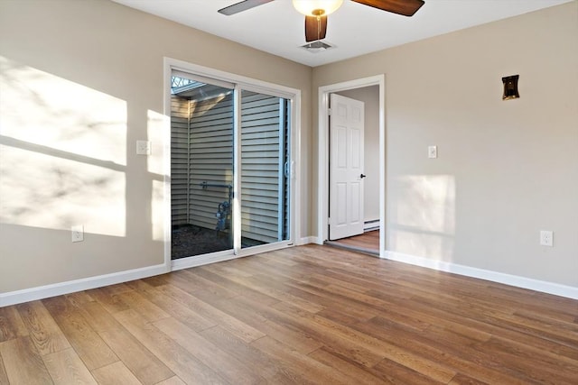 spare room with hardwood / wood-style floors, ceiling fan, and baseboard heating