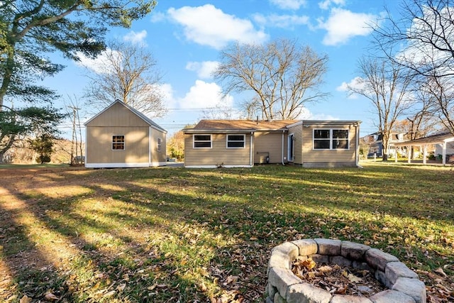 back of property featuring a yard and a fire pit