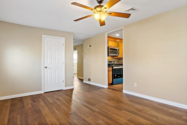 unfurnished room with ceiling fan and dark wood-type flooring