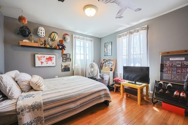 bedroom with radiator and hardwood / wood-style floors