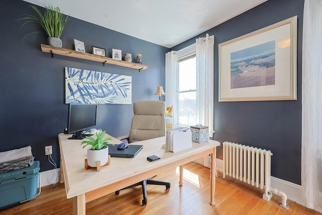 office featuring radiator heating unit, wood finished floors, and baseboards