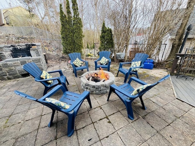 view of patio / terrace featuring fence, a wooden deck, and an outdoor fire pit