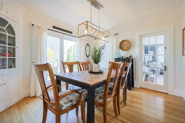 dining area featuring light wood-type flooring and ornamental molding