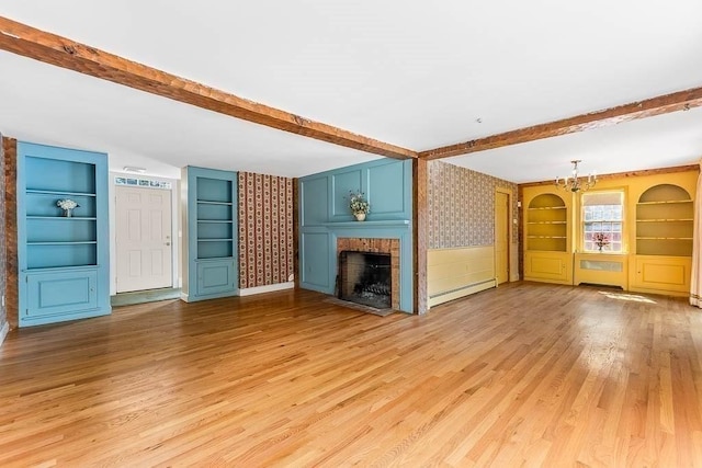 57 Rudon Dr, North Attleboro, MA 02760 - unfurnished living room with a baseboard radiator, built in shelves, light wood-style flooring, beam ceiling, and a chandelier