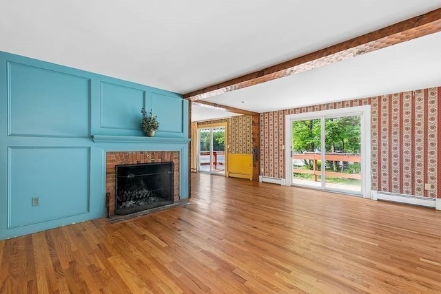 57 Rudon Dr, North Attleboro, MA 02760 - unfurnished living room with a brick fireplace, light wood-type flooring, beam ceiling, and baseboard heating