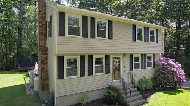 1000 Forest St, North Andover, MA 01845 - view of front facade featuring a trampoline, a chimney, and a front lawn