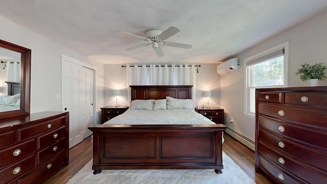 1000 Forest St, North Andover, MA 01845 - bedroom with an AC wall unit, baseboard heating, light wood-style floors, and ceiling fan