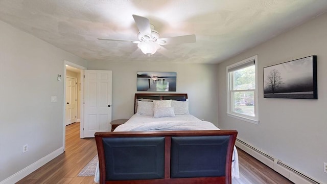 1000 Forest St, North Andover, MA 01845 - bedroom featuring a baseboard radiator, wood finished floors, baseboards, and ceiling fan
