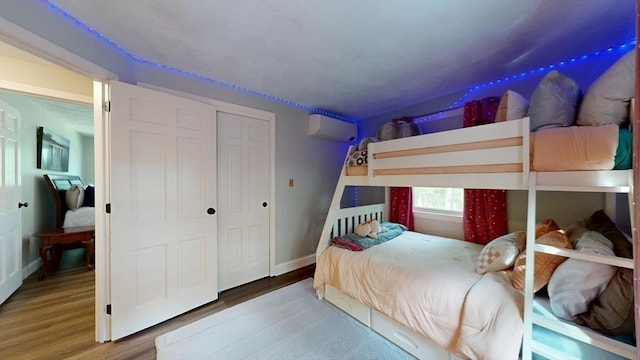 1000 Forest St, North Andover, MA 01845 - bedroom with a wall mounted AC, wood finished floors, baseboards, and a closet